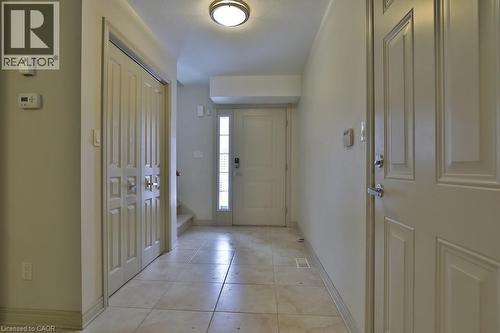 Entryway featuring neutral-toned tile flooring, flush mount ceiling light, and a paneled entry door with frosted glass sidelight - 7 Gibson Place Unit# 21, St. Catharines, ON - Indoor Photo Showing Other Room