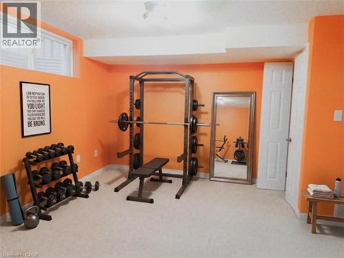 Basement rec area carpeted room featuring vibrant orange walls and white trim - 569 Activa Avenue, Kitchener, ON - Indoor Photo Showing Gym Room