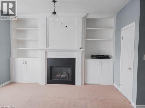Built-in white cabinetry framing a fireplace with a black firebox and mantel - 569 Activa Avenue, Kitchener, ON - Indoor With Fireplace