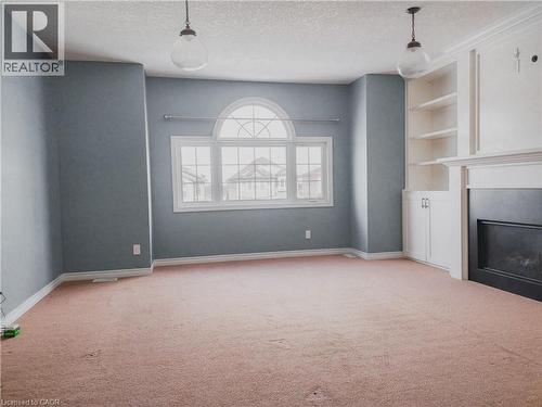 Spacious room featuring a prominent arched window with multiple panes - 569 Activa Avenue, Kitchener, ON - Indoor Photo Showing Other Room With Fireplace