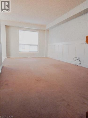 Spacious room featuring carpeting, a single window with blinds, and white wainscoting - 569 Activa Avenue, Kitchener, ON - Indoor Photo Showing Other Room