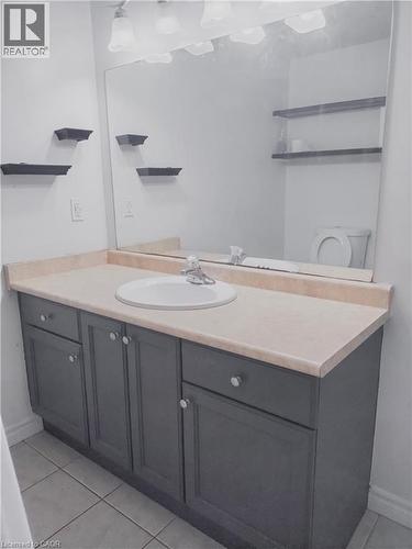 Bathroom vanity with a light-colored countertop, integrated sink, and dark cabinetry with silver-toned hardware - 569 Activa Avenue, Kitchener, ON - Indoor Photo Showing Bathroom