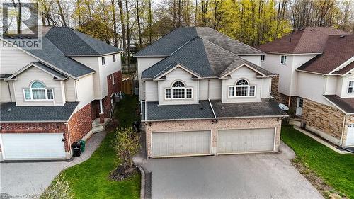 Two-story residential property featuring a two-car garage, light-colored siding, and brick accents - 569 Activa Avenue, Kitchener, ON - Outdoor