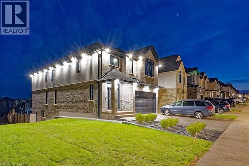 View of front of house featuring driveway, fence, a yard, brick siding, and a garage - 477 Blair Creek Drive, Kitchener, ON - Outdoor