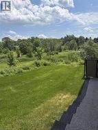 Expansive green space featuring a sloped lawn and natural landscaping - 