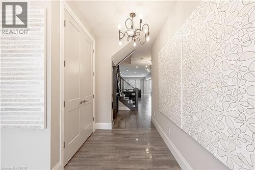 Corridor featuring baseboards, stairway, a chandelier, and wood finished floors - 477 Blair Creek Drive, Kitchener, ON - Indoor Photo Showing Other Room