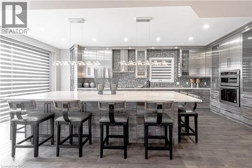 Kitchen with gray cabinetry, tasteful backsplash, double oven, and modern cabinets - 477 Blair Creek Drive, Kitchener, ON - Indoor