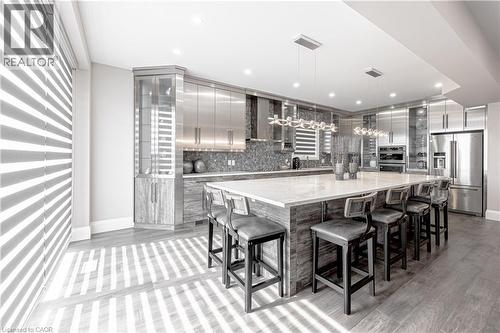 Kitchen featuring decorative light fixtures, modern cabinets, wall chimney range hood, appliances with stainless steel finishes, and decorative backsplash - 477 Blair Creek Drive, Kitchener, ON - Indoor Photo Showing Other Room