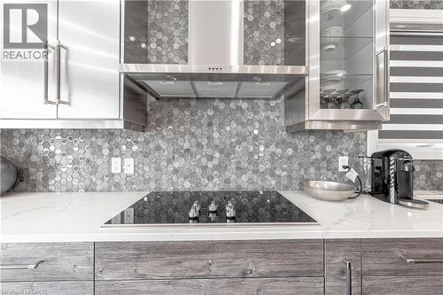 Kitchen featuring decorative backsplash, wall chimney exhaust hood, black electric stovetop, and modern cabinets - 477 Blair Creek Drive, Kitchener, ON - Indoor Photo Showing Kitchen With Upgraded Kitchen