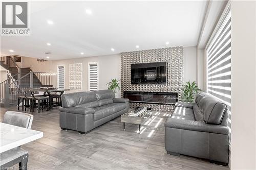 Living room with a tile fireplace, recessed lighting, stairway, and light wood-style floors - 477 Blair Creek Drive, Kitchener, ON - Indoor Photo Showing Living Room With Fireplace