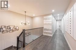 Hallway featuring wood-style flooring, an inviting chandelier, baseboards, and recessed lighting - 