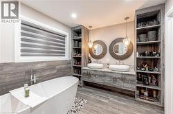 Full bath featuring a freestanding bath, double vanity, a sink, and ceramic tile finished floors - 
