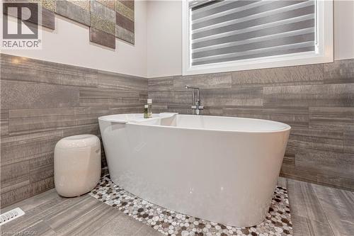 Bathroom with a soaking tub, tile walls, and wainscoting - 477 Blair Creek Drive, Kitchener, ON - Indoor