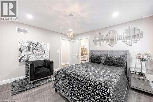 Bedroom featuring visible vents, baseboards, connected bathroom, and wood finished floors - 477 Blair Creek Drive, Kitchener, ON - Indoor Photo Showing Bedroom