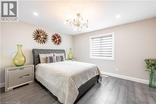 Bedroom featuring an inviting chandelier, wood finished floors, and baseboards - 477 Blair Creek Drive, Kitchener, ON - Indoor Photo Showing Bedroom