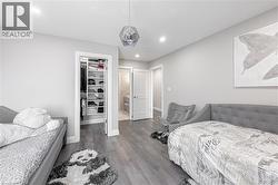 Bedroom featuring a closet, baseboards, a walk in closet, and wood finished floors - 
