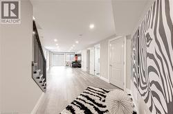 Corridor with stairway, light wood-type flooring, recessed lighting, and baseboards - 
