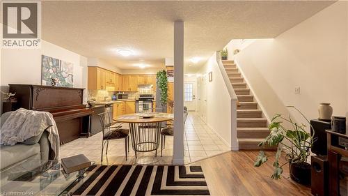 Kitchen featuring under cabinet range hood, light countertops, appliances with stainless steel finishes, light brown cabinetry, and tasteful backsplash - 85 Bankside Drive Unit# E34, Kitchener, ON - Indoor