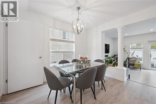 Dining area with wood-finish flooring, a contemporary overhead light fixture, and a large window with blinds - 11 Patton Drive, Cambridge, ON - Indoor Photo Showing Dining Room