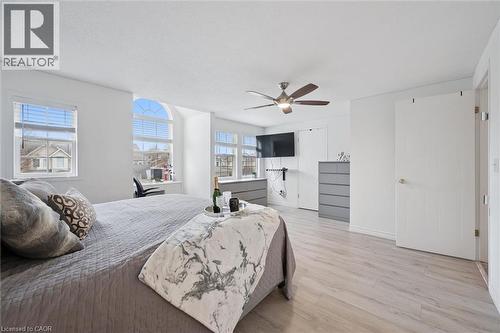 Spacious room with light wood-finish flooring, multiple windows, and a ceiling fan with integrated lighting - 11 Patton Drive, Cambridge, ON - Indoor Photo Showing Bedroom