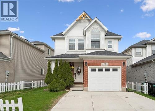 Two-story residence featuring a combination of brick and siding exterior, a front-facing garage with rectangular window inserts, and an arched transom window on the upper level - 11 Patton Drive, Cambridge, ON - Outdoor