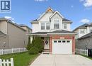 Two-story residence featuring a combination of brick and siding exterior, a front-facing garage with rectangular window inserts, and an arched transom window on the upper level - 11 Patton Drive, Cambridge, ON  - Outdoor 