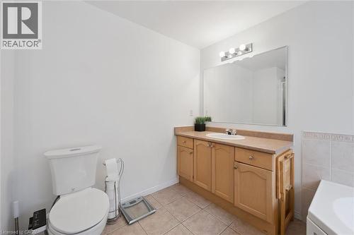 Bathroom featuring a light-toned vanity with an integrated sink, a large wall-mounted mirror, overhead lighting, and tile flooring - 11 Patton Drive, Cambridge, ON - Indoor Photo Showing Bathroom