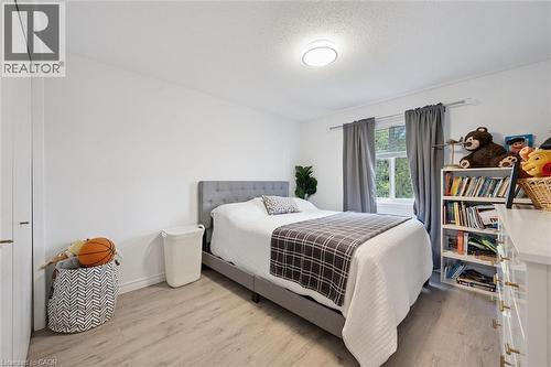 Bedroom featuring light wood-finish flooring, white walls, and a window with gray curtains - 11 Patton Drive, Cambridge, ON - Indoor Photo Showing Bedroom