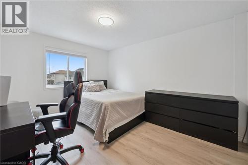 Bedroom featuring wood-finish flooring, a contemporary window, and a flush-mount ceiling light - 11 Patton Drive, Cambridge, ON - Indoor Photo Showing Bedroom