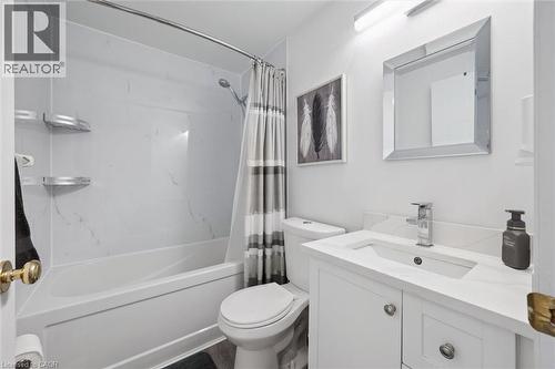 Bathroom featuring a full tub and shower combination with white surround, a white vanity with an integrated sink and light-toned countertop, and a framed mirror - 11 Patton Drive, Cambridge, ON - Indoor Photo Showing Bathroom