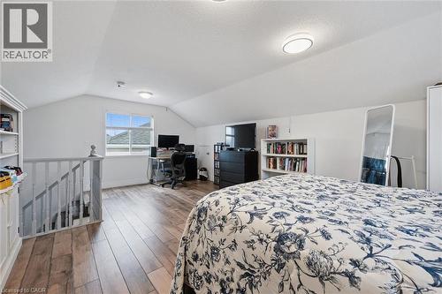 Spacious loft area featuring wood-finish flooring, a vaulted ceiling, and ample natural light from a prominent window - 11 Patton Drive, Cambridge, ON - Indoor Photo Showing Bedroom