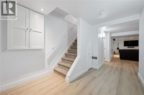 Light wood-finish flooring extending from the carpeted staircase to the open living space - 11 Patton Drive, Cambridge, ON - Indoor Photo Showing Other Room