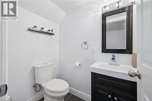 Powder room featuring a sleek black vanity with an integrated sink, a framed mirror, and chrome fixtures - 11 Patton Drive, Cambridge, ON - Indoor Photo Showing Bathroom