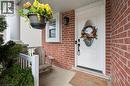 Brick exterior with white trim, a white front door featuring an oval glass insert, and a covered porch with a substantial white column and baluster railing - 11 Patton Drive, Cambridge, ON  - Outdoor With Exterior 