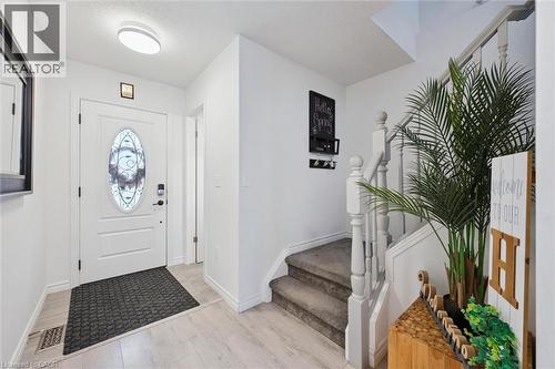 Entryway featuring a white door with an oval decorative glass insert, light wood-finish flooring, and a carpeted staircase with white balusters - 11 Patton Drive, Cambridge, ON - Indoor Photo Showing Other Room