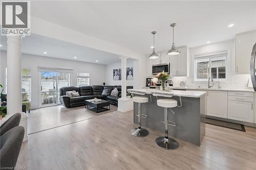 Bright kitchen featuring a central island with seating, pendant lighting, white cabinetry, and stainless steel appliances - 11 Patton Drive, Cambridge, ON - Indoor Photo Showing Kitchen With Upgraded Kitchen