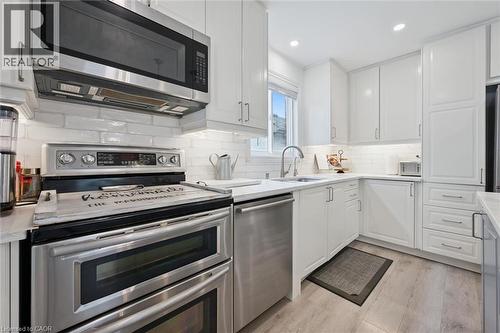 Kitchen featuring white cabinetry, stainless steel appliances, white subway tile backsplash, light wood-finish flooring, and recessed lighting - 11 Patton Drive, Cambridge, ON - Indoor Photo Showing Kitchen With Stainless Steel Kitchen With Upgraded Kitchen
