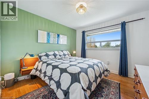 Hardwood flooring throughout featuring a window with exterior views and a neutral wall color - 154 Oriole Street, Waterloo, ON - Indoor Photo Showing Bedroom