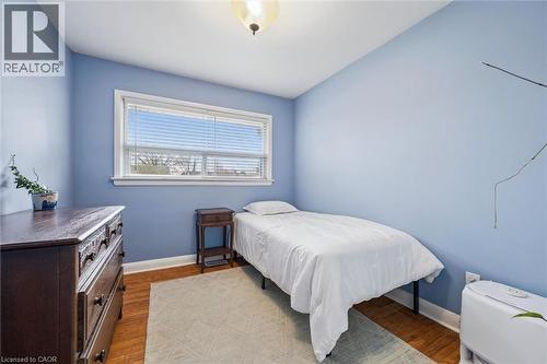Room featuring wood-finish flooring, a single window with white trim, and a ceiling-mounted light fixture - 154 Oriole Street, Waterloo, ON - Indoor Photo Showing Bedroom