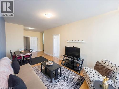 Open-concept living area featuring light wood-finish flooring, neutral wall paint, and white trim - 85 King Street W, Kitchener, ON 
