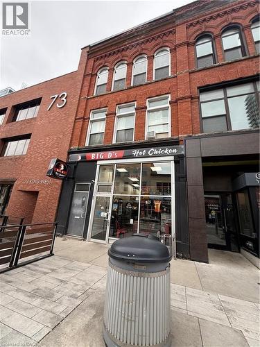 Red brick commercial facade with arched windows and a storefront entrance - 85 King Street W, Kitchener, ON 