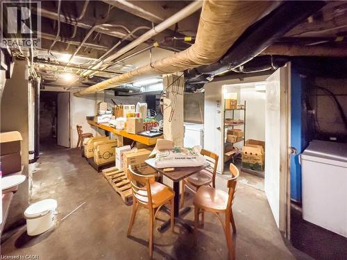 Basement area featuring exposed ceiling utilities, concrete flooring, and multiple storage options - 85 King Street W, Kitchener, ON 