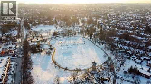 Expansive snow-covered parkland featuring a winding pathway, numerous trees, and a central tower structure - 85 King Street W, Kitchener, ON 