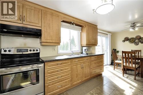 Kitchen featuring wood-finish cabinetry, stainless steel range, and stone-look countertops - 114 Bakersfield Drive, Cambridge, ON - Indoor Photo Showing Kitchen With Double Sink