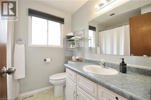 Bathroom featuring a white vanity with panel detailing, an oval undermount sink, and a speckled countertop - 114 Bakersfield Drive, Cambridge, ON - Indoor Photo Showing Bathroom