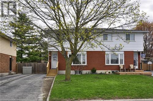 Two-story brick and siding residence featuring a front lawn, paved driveway, and established tree - 114 Bakersfield Drive, Cambridge, ON - Outdoor