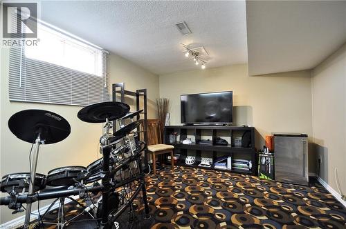 Entertainment room featuring a patterned low-pile carpet, a large window with blinds, and recessed ceiling lighting - 114 Bakersfield Drive, Cambridge, ON - Indoor Photo Showing Other Room