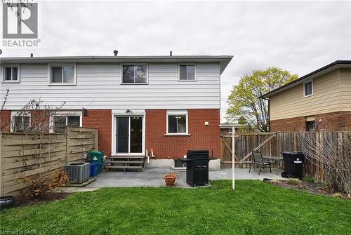 Expansive backyard featuring a manicured lawn, concrete patio, and full privacy fencing - 114 Bakersfield Drive, Cambridge, ON - Outdoor With Exterior