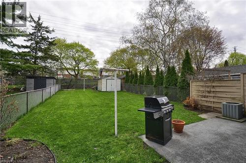 Spacious backyard featuring a manicured lawn, concrete patio, and mature trees - 114 Bakersfield Drive, Cambridge, ON - Outdoor With Backyard