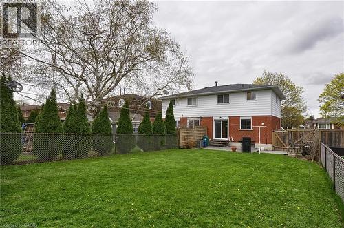 Expansive green lawn with a chain-link perimeter fence - 114 Bakersfield Drive, Cambridge, ON - Outdoor